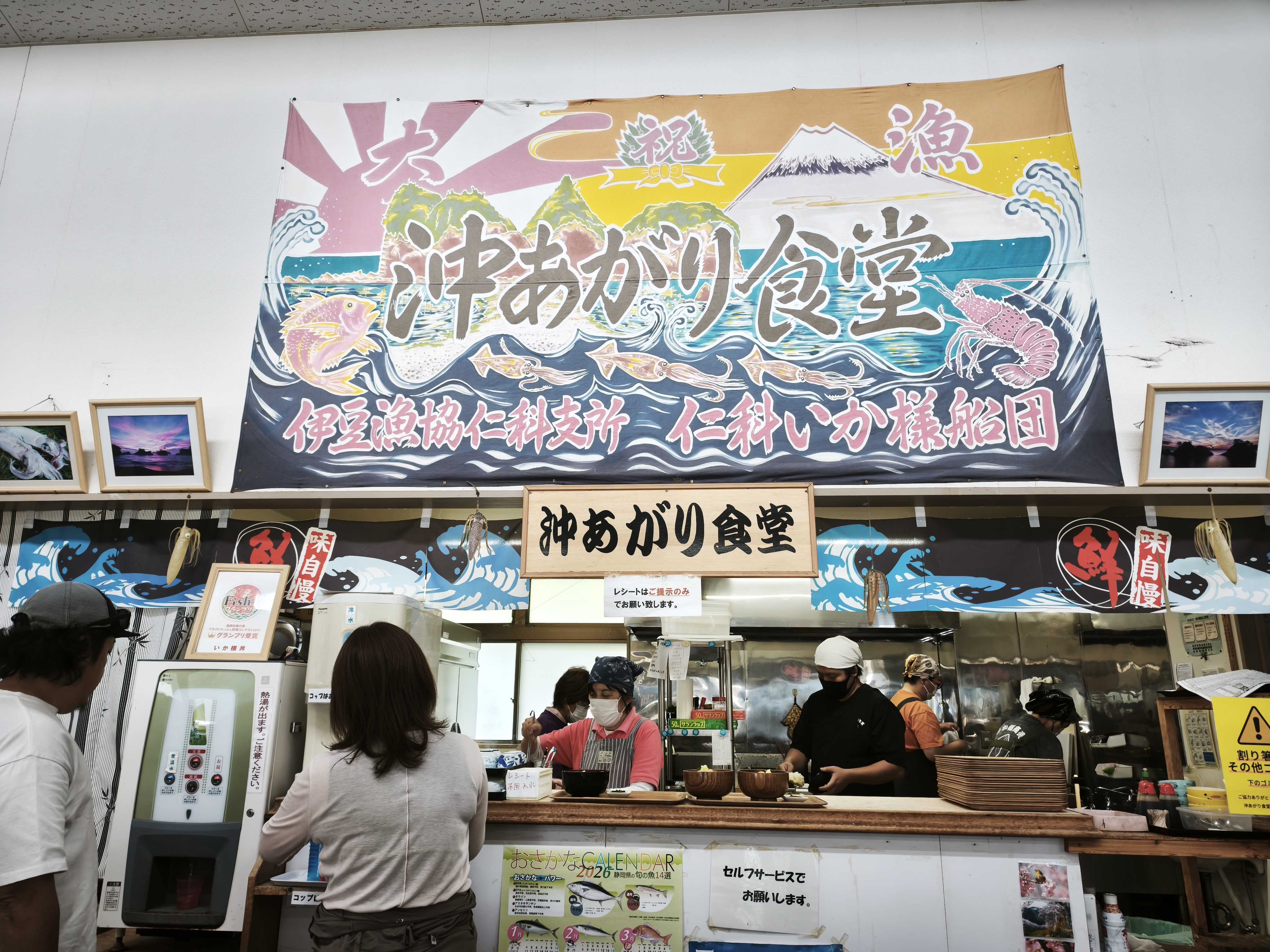 沖あがり食堂のカウンターと仁科いか様船団の大きな横断幕